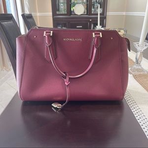 Burgundy Michael Kors Bag with a detachable strap.